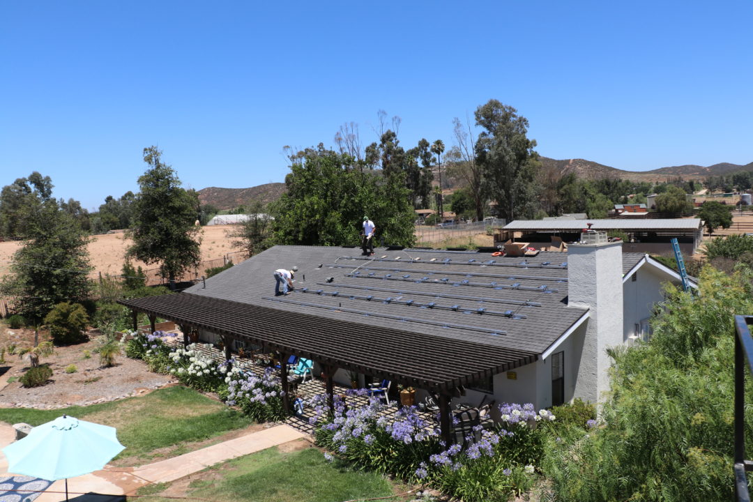 A man standing on the roof of a house