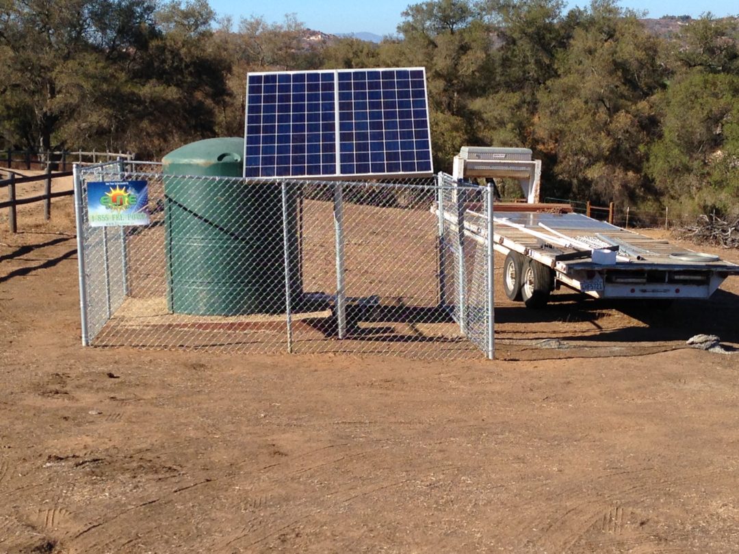 A solar panel mounted on the side of a fence.